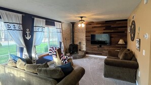Ein Wohnzimmer mit einer Couch, einem Fernseher und einem Kamin.