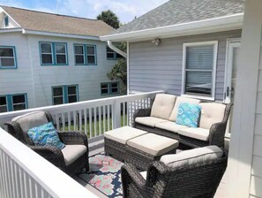 Enjoy a peaceful outdoor space with a wicker seating area and a view of the surrounding neighborhood.