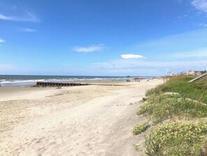 Enjoy a serene beach experience with a tranquil sea view and access to a wooden pier.