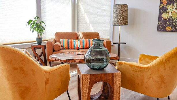 A living room with a sofa, two armchairs, a coffee table, and a floor lamp. - The Wildflower Inn (Gold Beach)
