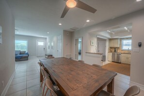 A spacious dining area with a wooden table and chairs, a ceiling fan, and recessed lighting. - Vacation Home Near the Beach! (Naples)