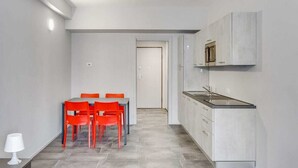 A compact kitchen with white cabinets and a countertop.