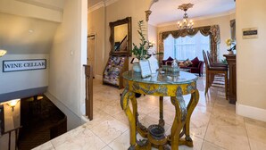 A grand reception area with a marble floor, a reception desk, a wine cellar sign, and a chandelier. - Charming King Suite•Historic Mansion Near Monterey (Salinas)