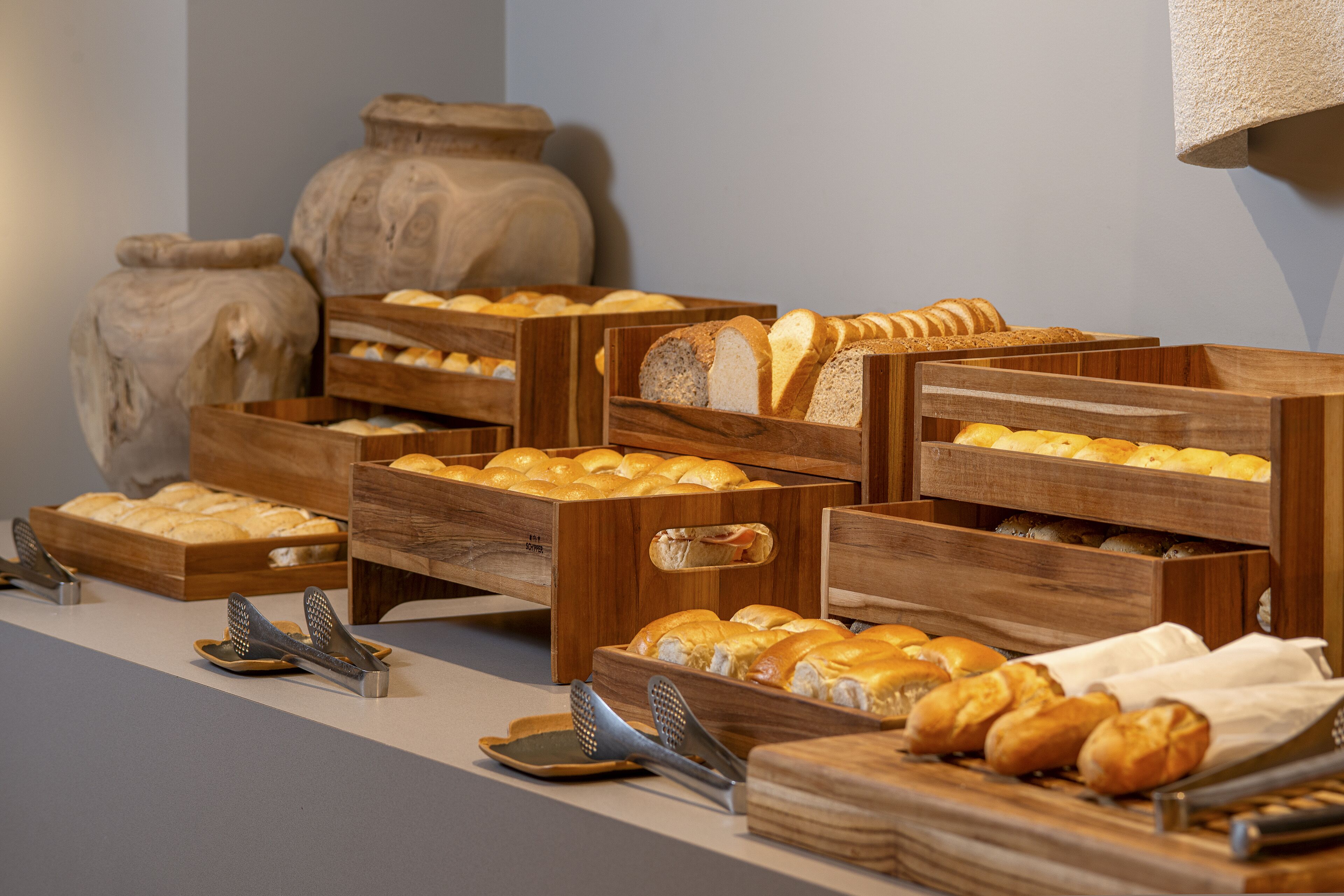 A variety of breads and pastries displayed in wooden crates on a counter.