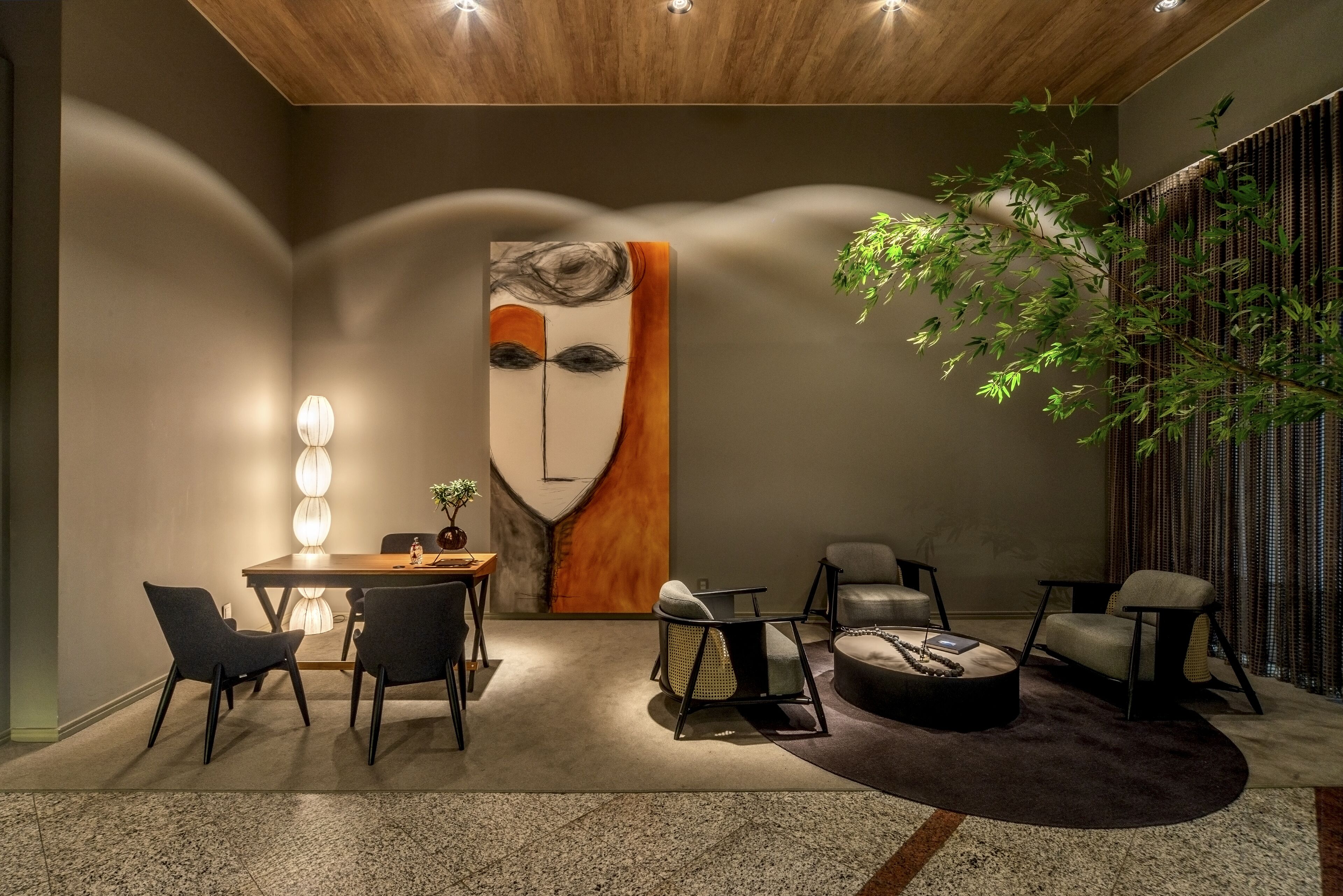 A modern interior with a dining area, seating, and a large abstract painting.