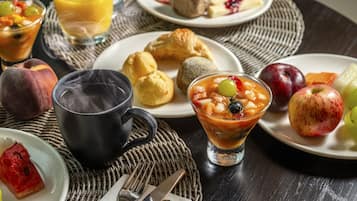 A breakfast setting with various dishes, a coffee cup, and a glass of juice.