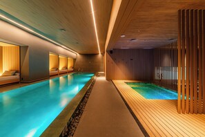 Ein moderner, überdachter Pool mit Holzvertäfelung und einem langen Gang.