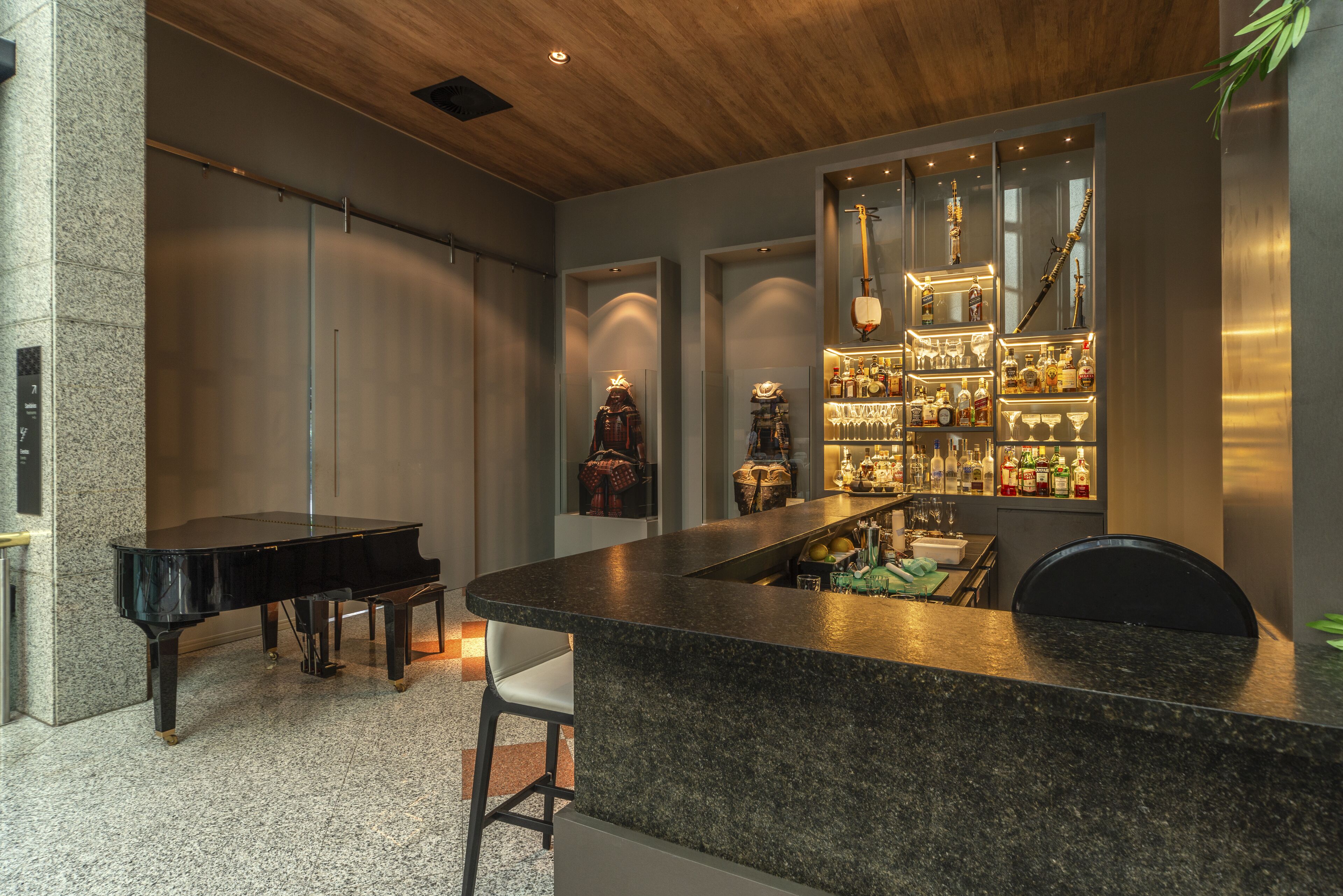 Un intérieur moderne avec un piano, un coin bar et un espace salon.