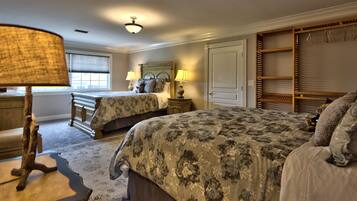 A bedroom with two beds, a wooden wardrobe, a lamp, and a window.