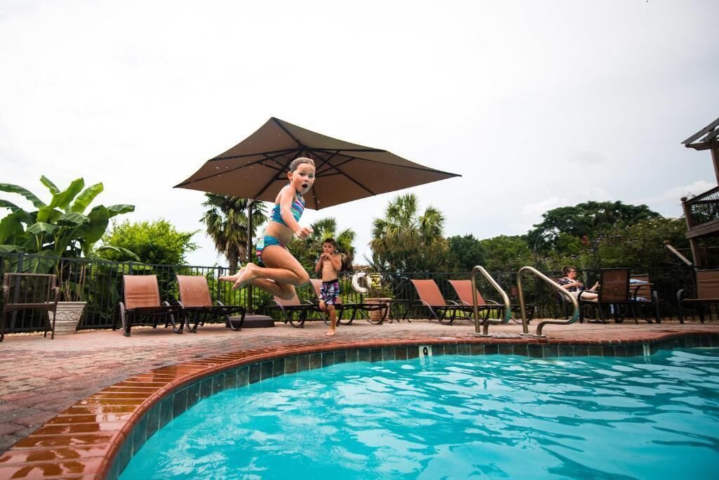 Une piscine avec des chaises longues et des parasols.