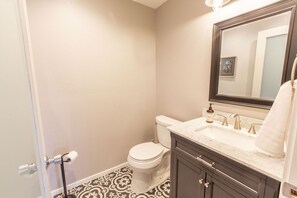 Une salle de bain avec des toilettes, un lavabo et un miroir.