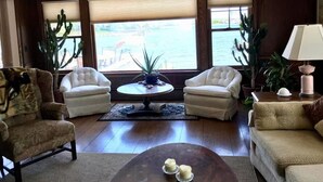Een zithoek met twee fauteuils, een bijzettafeltje en uitzicht op het water.