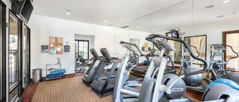 A gym with treadmills, ellipticals, and exercise balls.