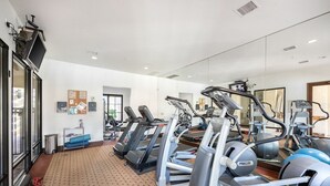 A gym with treadmills, ellipticals, and exercise balls.