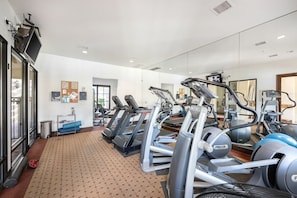 A gym with treadmills, ellipticals, and exercise balls.