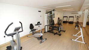 A gym with cardio machines, weightlifting equipment, and a mirror on the wall. - Apart beira mar Cabo Branco by Carpediem (João Pessoa)