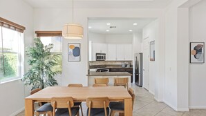 A modern kitchen with white cabinets, a central island, and stainless steel appliances. - Experience luxury at Desert Retreat, a haven in La Quinta, near PGA West. (La Quinta)