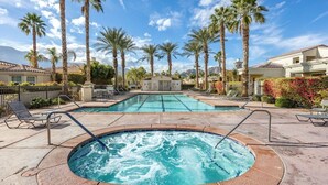 A pool area with a hot tub, lounge chairs, and palm trees. - Resort Living | Gym, Pool, Lounge & Spa Serenity (La Quinta)