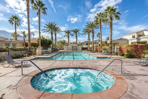 A pool area with a hot tub, lounge chairs, and palm trees. - Resort Living | Gym, Pool, Lounge & Spa Serenity (La Quinta)
