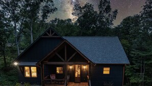 A cabin with a porch, wooden deck, and a view of the night sky. - Hot Tub- Modern Luxury -5 Bdrm-4 Kings- Pool Table (Blue Ridge)