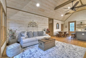 A spacious living room with a large sofa, a wooden coffee table, and a marble rug. - Hot Tub- Modern Luxury -5 Bdrm-4 Kings- Pool Table (Blue Ridge)
