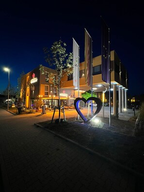 A modern building with a prominent heart-shaped sculpture in front. - Hotel Winterrot (Karlsruhe)