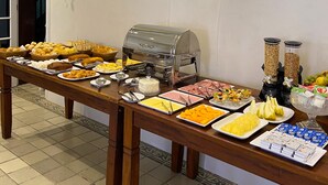 Une table de buffet proposant divers plats, un grill et deux distributeurs de boissons.