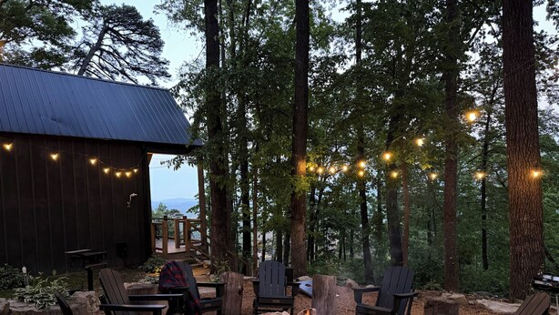 An outdoor seating area with Adirondack chairs, a fire pit, and string lights. - Summer Escape | Hot Tub (Sevierville)