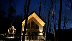 A cabin with a wooden exterior, a balcony, and a large window. - Early Fall Getaway - 2 (Sevierville)