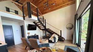 Un intérieur moderne comprenant un coin repas, un escalier et une grande fenêtre.