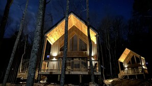 Une cabane avec une façade en bois, un balcon et une véranda.