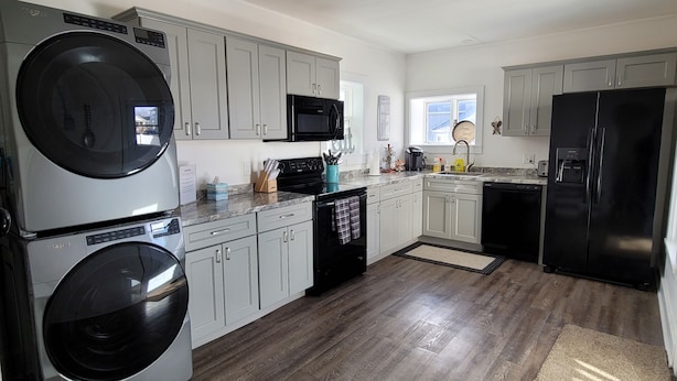 A modern kitchen with stainless steel appliances, grey cabinets, and a wooden floor. - 5-Mins to Cedar Point, 4-bedroom house. (Sandusky)
