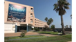 Ein Gebäude mit einer großen Werbetafel, die die Villa del Sol Eigentumswohnungen mit täglichen, wöchentlichen und monatlichen Mietangeboten bewirbt.