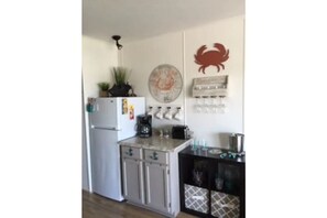 A compact kitchen with a refrigerator, a coffee maker, and a small countertop. - Beautiful Bayfront Water View (Corpus Christi)