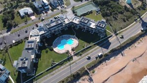 An aerial view of a modern building with a central courtyard and a swimming pool. - Ocean Views surrounded by parks & secluded beaches (Flagler Beach)