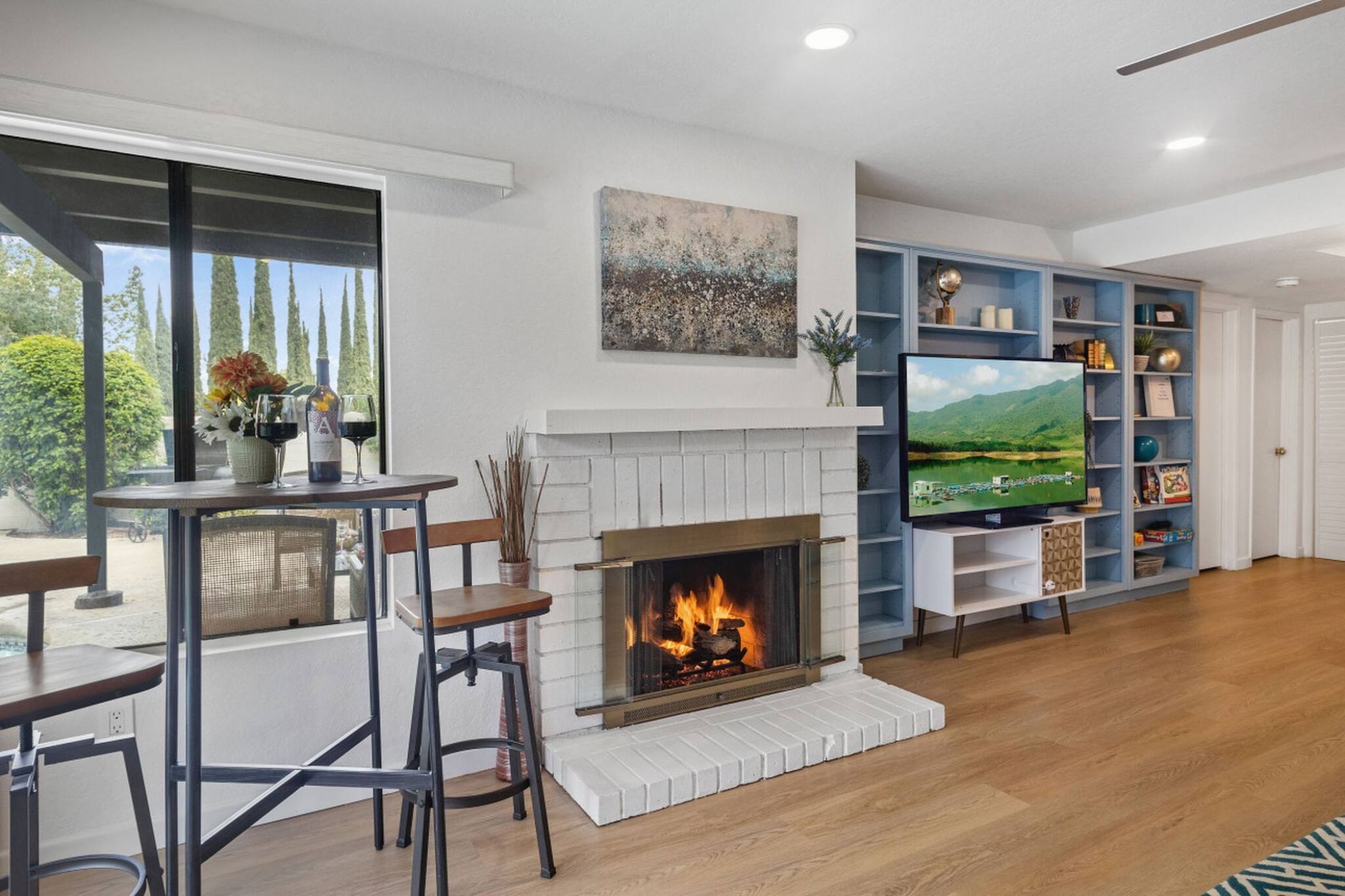 A living room with a fireplace, a television, and a bookshelf.