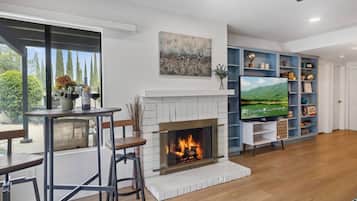 A living room with a fireplace, a television, and a bookshelf.
