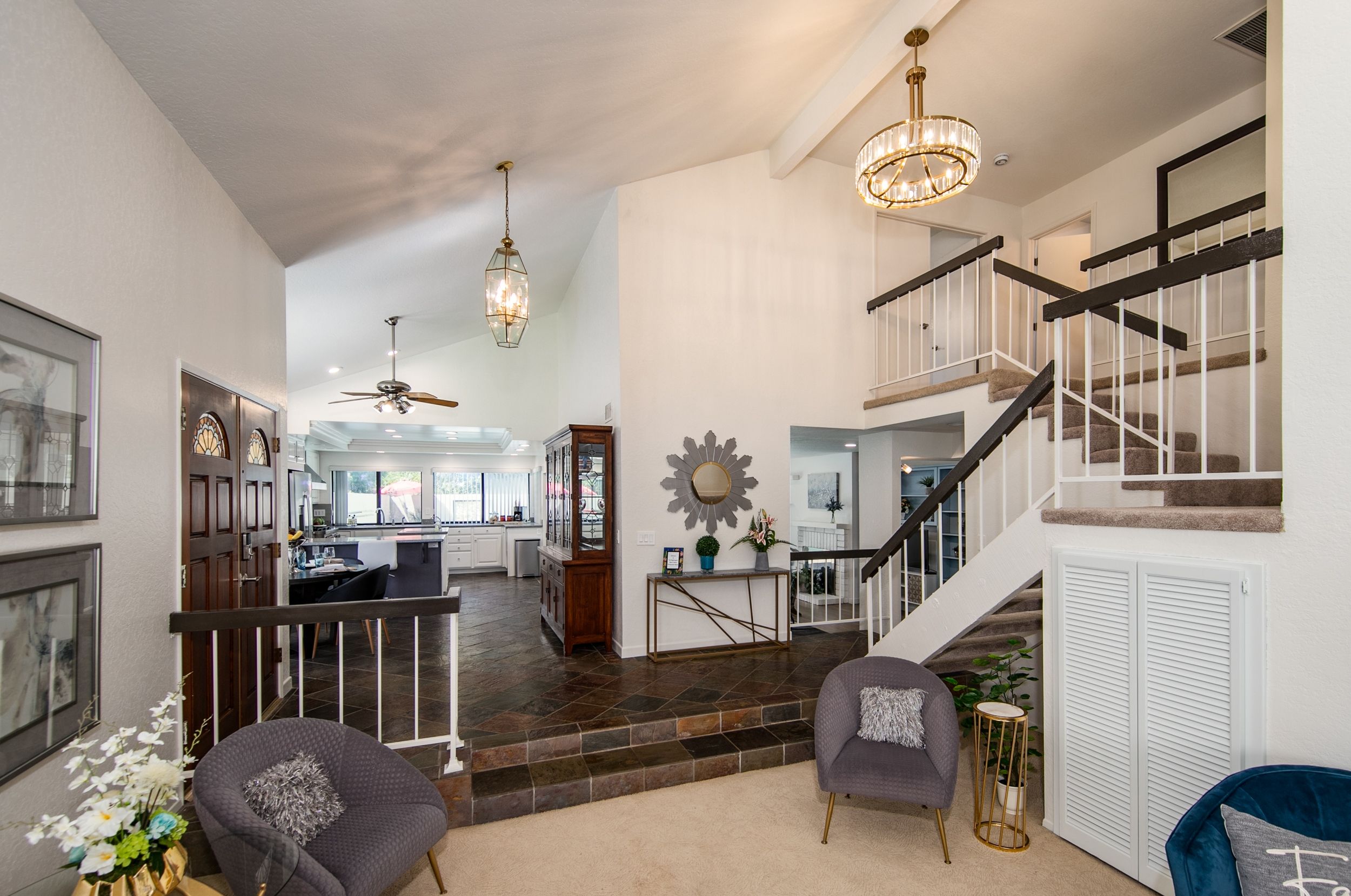 A spacious living area with a staircase, a dining area, and a kitchen.