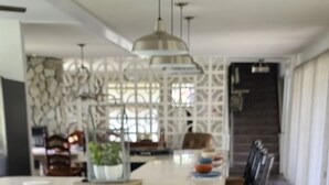 A spacious kitchen with a large island, dark wood flooring, and pendant lighting. - Mid-Century Family Home - Corporate Relocatio  Rental (Charlotte)