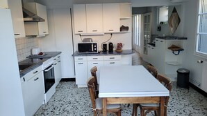 A compact kitchen with white cabinets, a microwave, a toaster, and a dining table with chairs. - Bléré hyper center near Chenonceau and Beauval zoo evening meal possible (Bléré)
