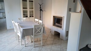 A dining area with a table and chairs, a cabinet with glass doors, and a fireplace. - Bléré hyper center near Chenonceau and Beauval zoo evening meal possible (Bléré)