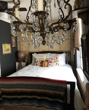 Una cama con un edredón estampado, una araña y un globo terráqueo en una mesita de noche.