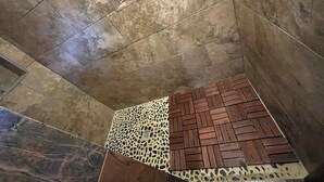 A room with a tiled floor, a patterned rug, and a small window with a decorative item.
