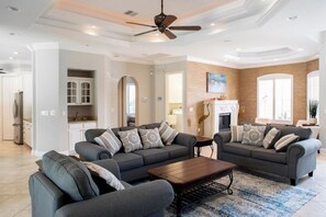 Relax in this stylish living area with a large sofa, coffee table, and fireplace.