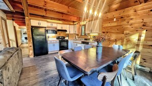 A modern kitchen with wooden cabinets, a dining table with chairs, and a refrigerator. - The Challenge House-mega games-hottub-beach-lake-The ultimate Poconos game house (Blakeslee)