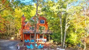 A rustic cabin with a balcony, surrounded by autumn foliage. - The Challenge House-mega games-hottub-beach-lake-The ultimate Poconos game house (Blakeslee)