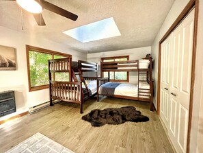 Dormitorio con literas, tragaluz, ventana grande y puerta.