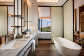 A modern bathroom with a large bathtub, a double sink, and a large mirror. There is a window providing a view of the outdoors. - Wyndham Grand Plaza Royale Xiangai Mountain Fuzhou (Fuzhou)