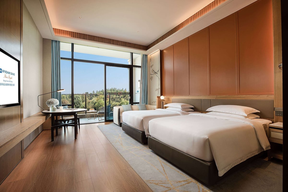 Ein modernes Hotelzimmer mit einem großen Bett, einem Schreibtisch und Blick ins Freie.