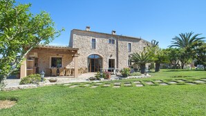 Un edificio de piedra con un patio y mobiliario para exteriores.